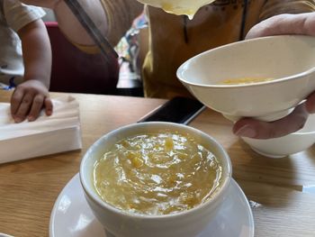 High angle view of woman holding tea cup on table