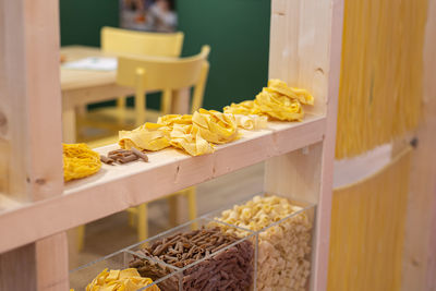 Uncooked tagliatelle italian pasta on a wooden shelf.