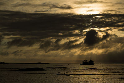 Silhouette boat sailing on sea against sky during sunset