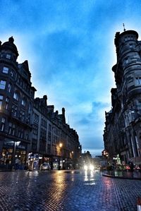 Buildings in city against cloudy sky