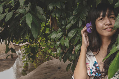 Portrait of young woman looking at plants