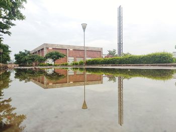 Reflection of building in lake against sky