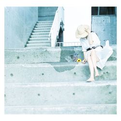 Rear view of woman sitting on staircase