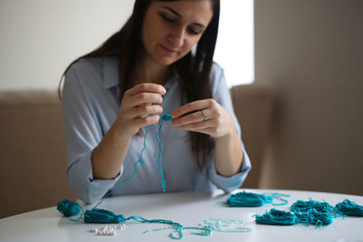 Craftswoman makes brushes from threads. concept creativity and handmade, toning in the real interior