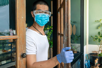 Portrait of man standing in front of window