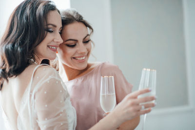 Bridesmaid and bride holding champagne flute