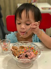 Portrait of cute girl with ice cream on table