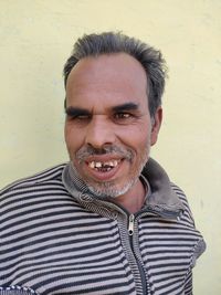 Portrait of a smiling young man against wall