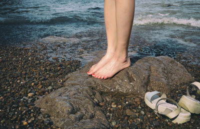 Low section of woman standing on beach