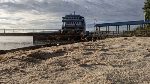 Pier on beach against sky