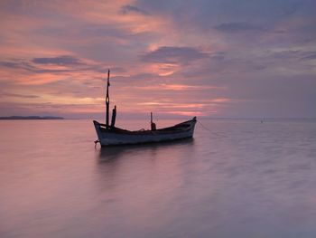 Sailboat in sea against sky during sunset