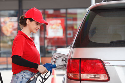 Female worker filling gas in car