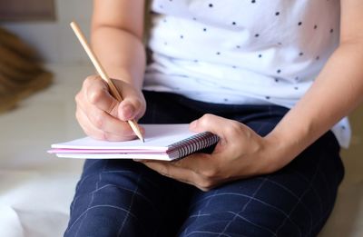 Midsection of woman reading book