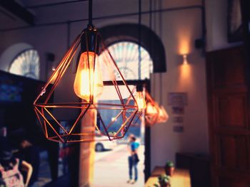 Close-up of illuminated lamp at sunset