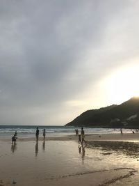 People on beach against sky