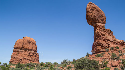 Low angle view of rock formation against clear blue sky