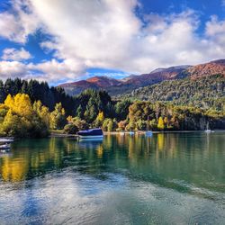 Scenic view of lake by trees against sky