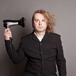 Portrait of man with hairdryer