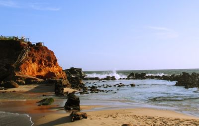 Rock formation on beach against sky