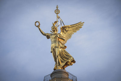 Low angle view of angel statue against blue sky