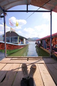 Low section of person on boat against sky