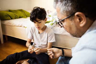 Father and son playing with rubber bands at home