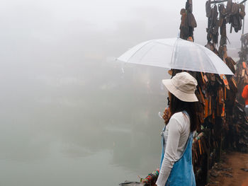 Rear view of woman holding umbrella