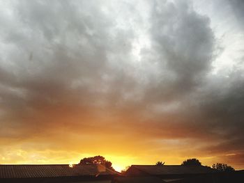 Silhouette of building against cloudy sky