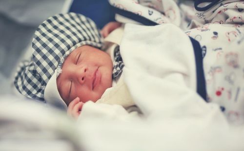 Close-up of baby sleeping on bed