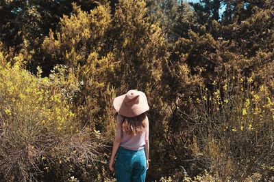 Woman standing against trees in forest