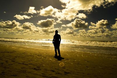 People standing on beach at sunset