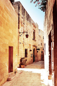 Narrow alley amidst buildings against sky