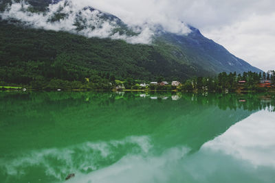 Beautiful calm mountain lake on cloudy day with reflection on still water. 