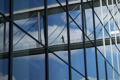 Reflection of pedestrian bridge on building window