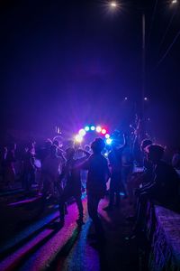 Men dancing during event in city at night