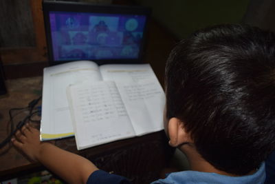 High angle view of boy studying at home