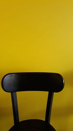 Close-up of chair against yellow background