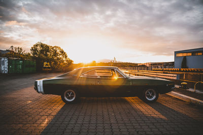 Cars on road against sky during sunset