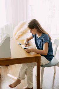Side view of woman working at home