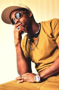 Close-up of young man wearing sunglasses sitting at home