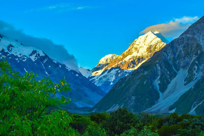 Scenic view of snowcapped mountains against blue sky