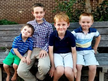 Portrait of smiling boys sitting outdoors