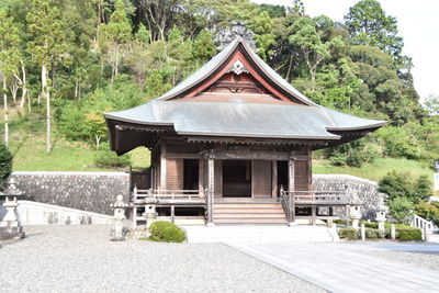 Exterior of temple by building in forest