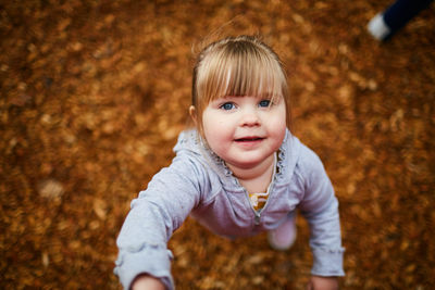 High angle view of cute girl standing at park during autumn