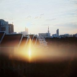 Buildings in city against sky during sunset