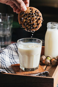 Cropped image of person holding cookie on table