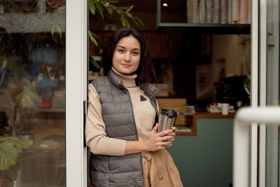 Portrait of young woman standing in store