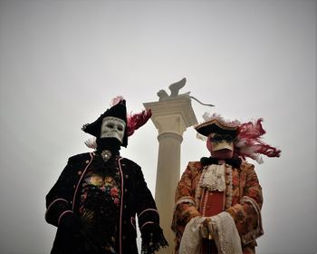 Low angle view of men against clear sky