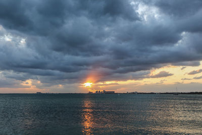 Scenic view of sea against dramatic sky during sunset