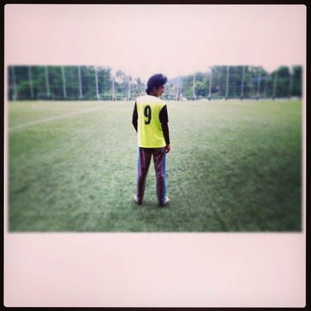 transfer print, auto post production filter, full length, lifestyles, childhood, leisure activity, rear view, boys, casual clothing, focus on foreground, standing, elementary age, front view, sport, yellow, grass, field, portrait